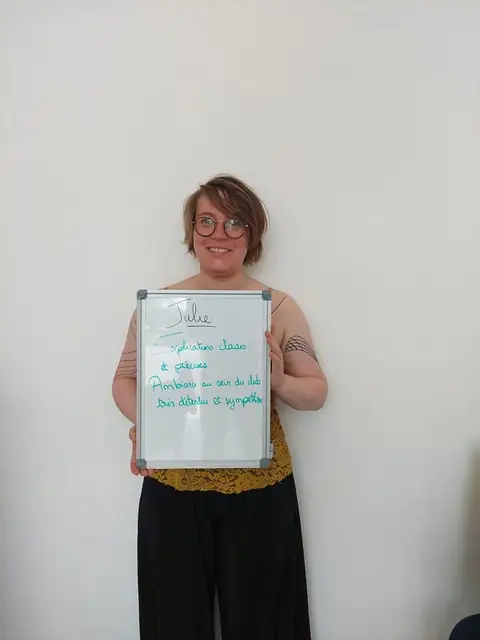 Souriante, une membre brandit l’ardoise où son bilan est écrit
